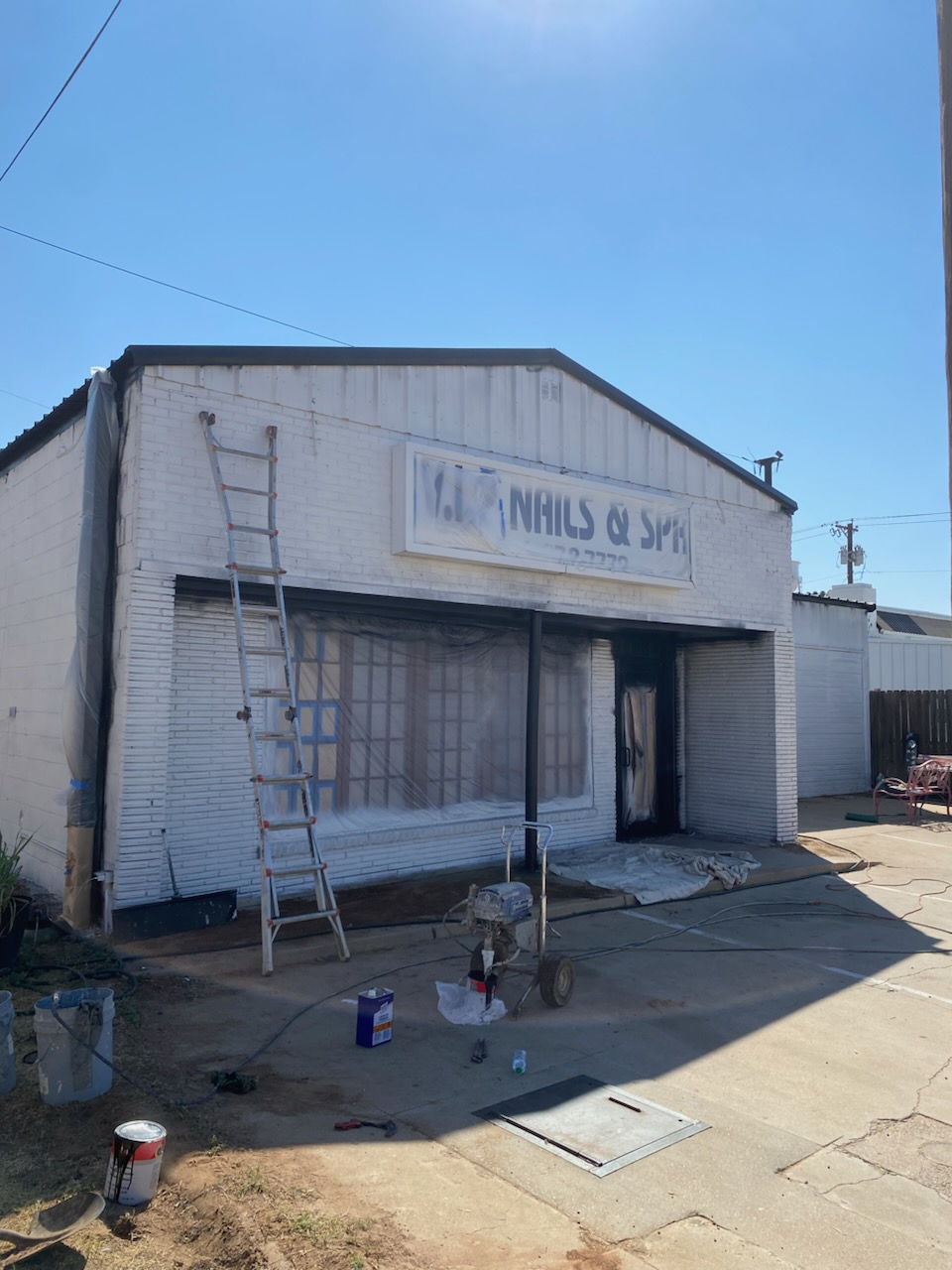 Commercial building exterior mid-repaint with new window trim Lubbock